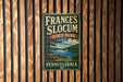 A vintage-style metal sign for Frances Slocum State Park in Pennsylvania, featuring a scenic landscape with a lake, trees, and a sailboat.