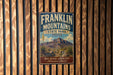 A vintage Franklin Mountains State Park sign is displayed on a wooden wall.