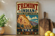 a vintage-style sign for Fremont Indian State Park & Museum, with a desert landscape and rock art illustration, placed on a wooden surface next to a cutting board and some lemons.