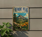 A vintage metal sign for Fremont Peak State Park in California, featuring a scenic mountain landscape with pine trees, flowers, and a winding path.