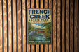 A vintage metal sign for French Creek State Park in Pennsylvania, featuring an illustration of a heron and a bridge over a river.