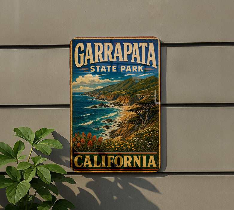 A vintage-style metal sign for Garrapata State Park in California, featuring a scenic coastal landscape with mountains, cliffs, and the ocean.
