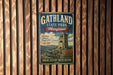 A vintage metal sign for Gathland State Park, Maryland, featuring a tower and a cannon, mounted on a wooden wall.