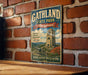 A vintage metal sign for Gathland State Park in Maryland, featuring a castle and a cannon, mounted on a brick wall.