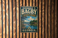 A vintage metal sign for George T. Bagby State Park in Georgia, featuring a scenic landscape with a river, trees, and a dam.