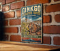 A vintage-style metal sign for Ginkgo Petrified Forest State Park in Washington, featuring a colorful illustration of a tree stump and a mountain backdrop.