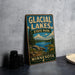 A vintage metal sign for Glacial Lakes State Park in Minnesota, featuring a scenic landscape with a lake, mountains, and pine trees.
