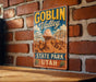 A vintage-style sign for Goblin Valley State Park in Utah, featuring a desert landscape with a large rock formation.