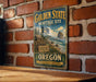 A vintage-style sign for the Golden State Heritage Site in Oregon, featuring a scenic illustration of the state's natural beauty.