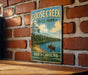 A vintage-style metal sign for Goose Creek State Park in North Carolina, featuring a scenic image of a person in a canoe on a lake surrounded by pine trees.