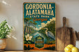 A vintage-style metal sign for Gordonia-Alataha State Park in Georgia, featuring a scenic illustration of the park's natural surroundings.