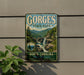 A vintage metal sign for Gorges State Park, featuring a scenic mountain landscape with a waterfall.