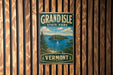 A vintage-style metal sign for Grand Isle State Park in Vermont, featuring a scenic landscape with a sailboat on the water.