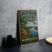 A vintage-style sign for Great River Bluffs State Park in Minnesota, featuring a scenic landscape with a river, mountains, and a bird in flight.