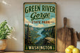A vintage-style sign for Green River Gorge State Park in Washington, featuring a scenic mountain landscape with a river and pine trees.