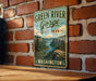 A vintage-style metal sign for Green River Gorge State Park in Washington, featuring a scenic mountain landscape with a river and pine trees.