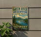 A vintage-style sign for Green River Reservoir State Park in Vermont, featuring a scenic landscape with mountains, trees, and a lake.