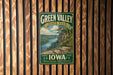 A vintage-style metal sign for Green Valley State Park in Iowa, featuring a scenic landscape with a river, cliffs, and trees.