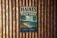 A vintage metal sign for Haines Memorial State Park, featuring a scenic coastal landscape with a beach, ocean, and trees.