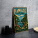 A vintage-style metal sign for Hamburg State Park in Georgia, featuring a scenic illustration of a river, trees, and a waterfall.