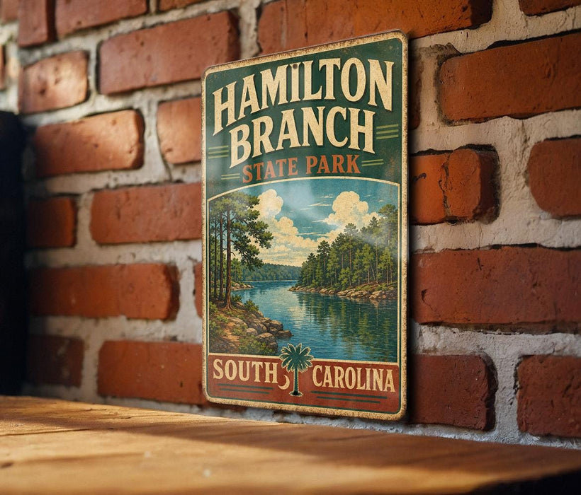 A vintage metal sign for Hamilton Branch State Park in South Carolina is displayed on a brick wall.