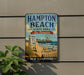 A vintage metal sign for Hampton Beach State Park in New Hampshire, featuring a beach scene with a lifeguard chair, a ferris wheel, and a sign that says "Hampton Beach State Park".