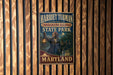 A vintage-style metal sign for Harriet Tubman Underground Railroad State Park in Maryland, featuring an illustration of Harriet Tubman and the park's name.