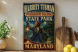 A vintage-style poster of Harriet Tubman, the Underground Railroad, and State Park in Maryland, featuring a woman holding a lantern and a wagon.