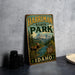 A vintage metal sign for Harriman State Park in Idaho, featuring a moose and a mountain landscape.