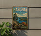 A vintage-style metal sign for Harriman State Park in New York, featuring a scenic landscape with a lake and mountains.