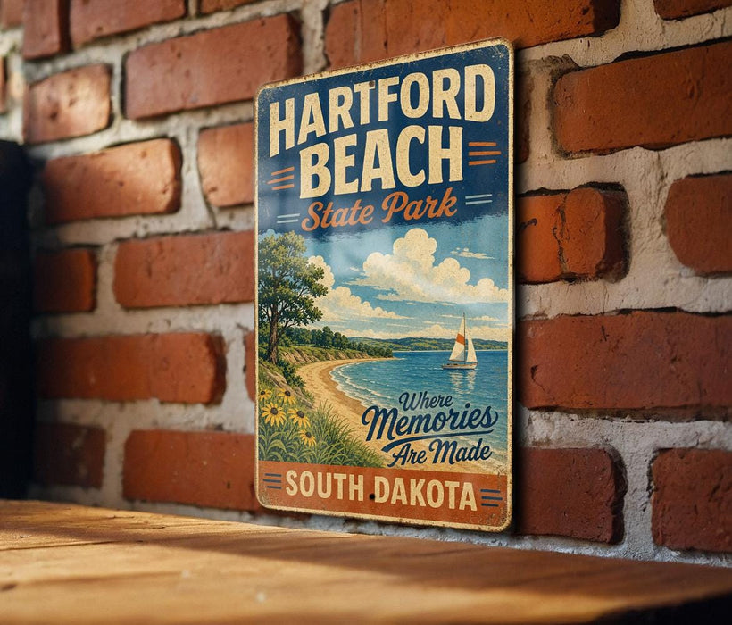 A vintage-style metal sign for Hartford Beach State Park in South Dakota, featuring a scenic illustration of a beach and a sailboat.