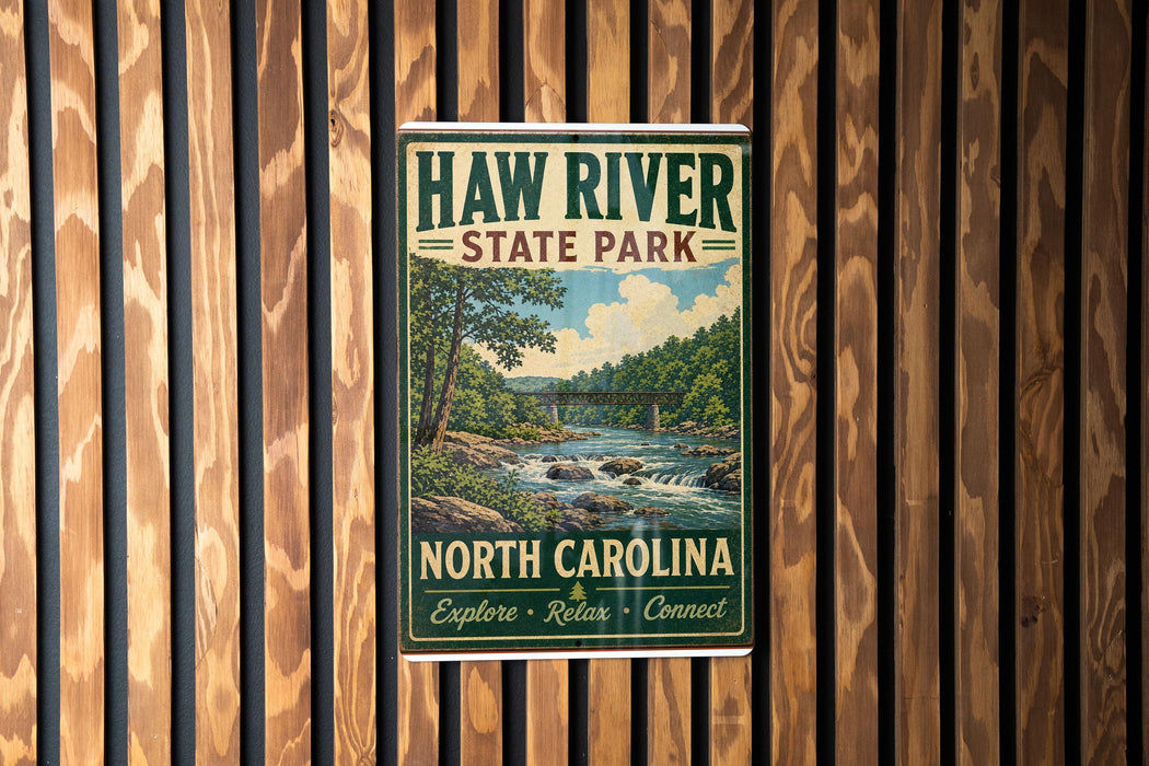 A vintage-style metal sign for Haw River State Park in North Carolina, featuring a scenic illustration of a river and forest landscape.