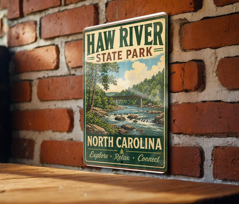 A vintage-style sign for Haw River State Park in North Carolina, featuring a scenic illustration of a river and forest landscape.
