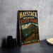 A vintage metal sign for Haystack Mountain State Park in Connecticut, featuring a scenic mountain landscape and trail signs.