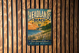 A vintage-style metal sign for Headlands Beach State Park in Ohio, featuring a scenic beach landscape with a lake and mountains in the background.