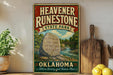 A vintage-style sign for the state park called "Heavenstone State Park" in Oklahoma, featuring a scenic illustration of a river and a large rock with ancient writing on it.