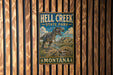 A metal sign for Hell Creek State Park in Montana, featuring a dinosaur illustration and the park's name.