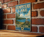 A vintage-style metal sign for Hempstead Lake, New York, featuring a scenic image of the lake and surrounding landscape.