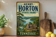 A vintage-style sign for Henry Horton State Park in Tennessee, featuring a scenic landscape with a lake and mountains.