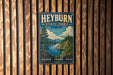 A vintage-style metal sign for Heyburn State Park, Idaho, featuring a scenic landscape with a river, mountains, and pine trees.