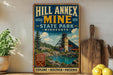 A vintage-style poster advertising Hill Annnex Mine in Minnesota, featuring a scenic landscape with a river, mountains, and a coal mine.