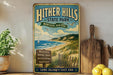 A vintage-style sign for Hither Hills State Park, featuring a beach, hiking trails, picnicking, and nature, with a wooden paddle and a potted plant in the foreground.