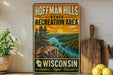 A vintage-style metal sign for Hoffman Hills State Recreation Area in Wisconsin, featuring a scenic landscape with a river, mountains, and trees.