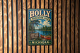 A vintage metal sign for the Holly Recreation Area in Michigan, featuring a scenic illustration of a lake, forest, and canoe.