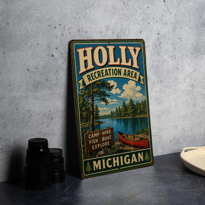 A vintage metal sign for the Holly Recreation Area in Michigan, featuring a scenic illustration of a lake, pine trees, and a red canoe.