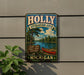 A vintage metal sign for the Holly Recreation Area in Michigan, featuring a scenic image of a lake, pine trees, and a red canoe.