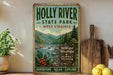 A vintage-style sign for Holly River State Park in West Virginia, featuring a scenic mountain landscape with a river and pine trees.