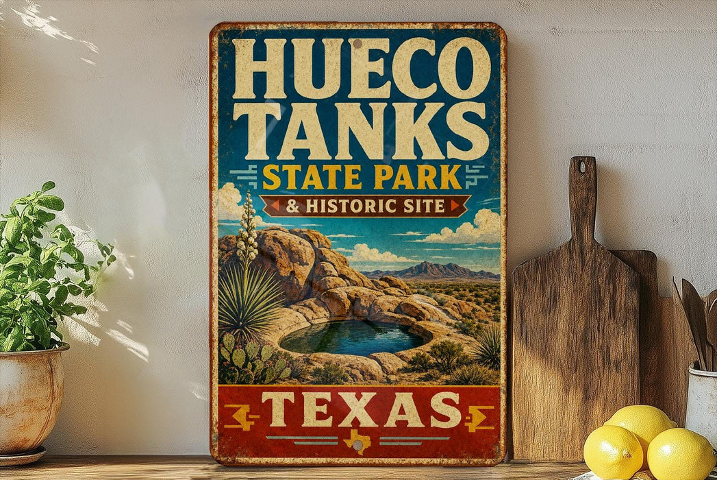 A vintage-style sign for Hueco Tanks State Park & Historic Site in Texas, featuring a desert landscape with a small lake and mountains in the background.