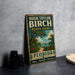 A vintage-style metal sign for Hugh Taylor Birch State Park in Florida, featuring a tropical landscape with palm trees and a path leading to the park.