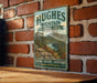 A vintage-style metal sign for the Hughes Mountain Natural Area in Missouri, featuring a scenic landscape with a river and mountains.